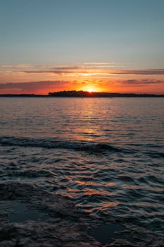 A breathtaking sunset over the ocean in Pula, Croatia, with vibrant colors and gentle waves.
