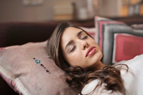 Free Woman Wearing White Shirt Laying on Bed Stock Photo