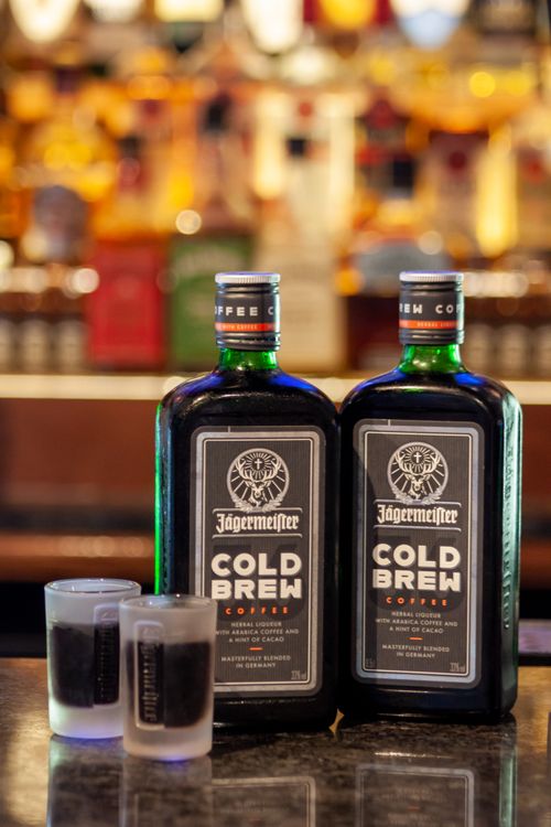 Free Close-up of Jägermeister Cold Brew bottles and shots on a bar counter. Stock Photo