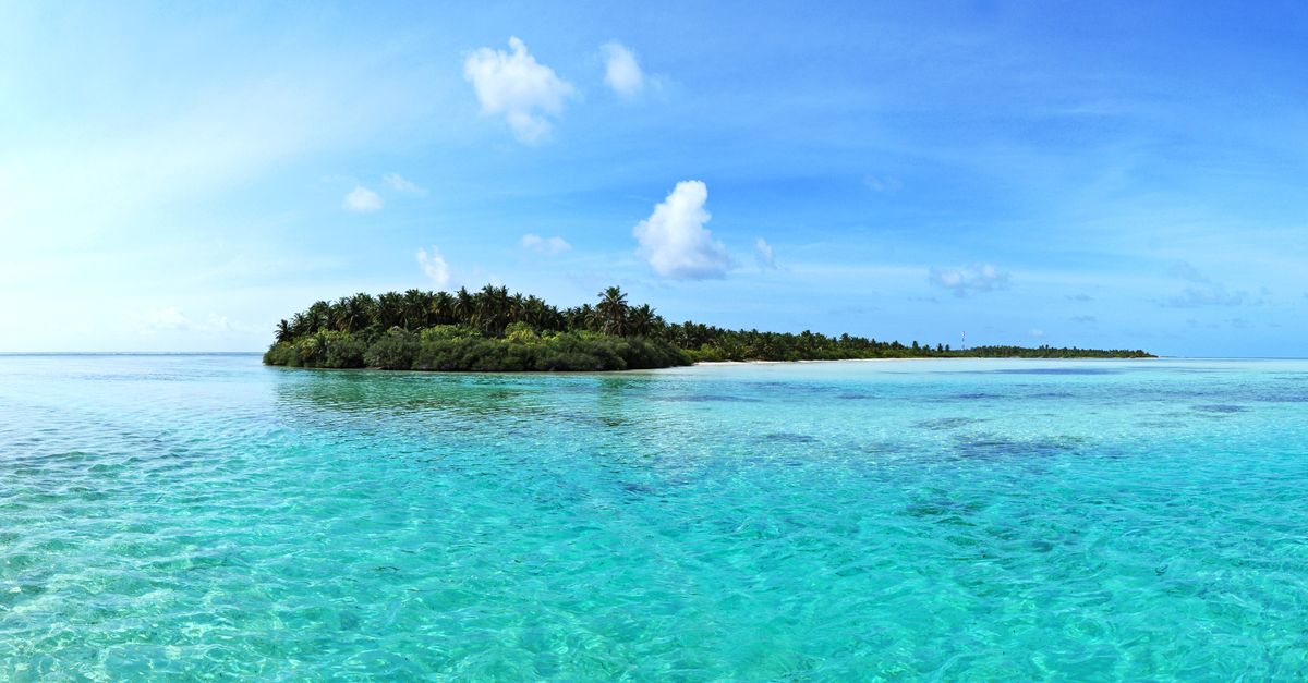 A tropical island ringed by clear shallow water.