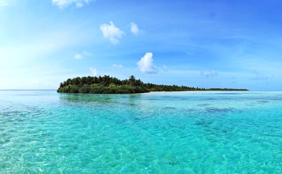 A beautiful tropical island surrounded by clear blue waters and a vivid sky, ideal for travel and vacation.