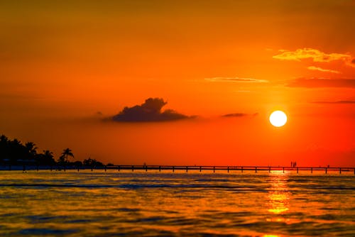 Body of Water Under Orange Sky 