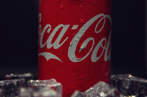 Free Close-up photo of a Coca-Cola can with dew droplets and ice cubes, refreshing concept. Stock Photo