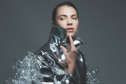 Photo of a Woman Touching the Collar of Her Silver Jacket