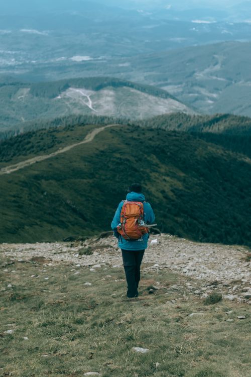 Free A lone backpacker walking on a mountain trail, enjoying a serene outdoor adventure. Stock Photo
