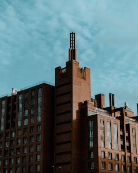 A striking modern brick building against a clear blue sky, showcasing unique architecture.
