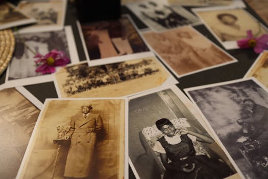 A collection of vintage sepia photographs scattered on a table, evoking nostalgia.