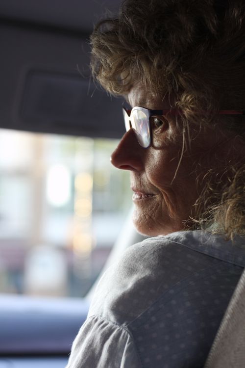 Free Close-up profile portrait of an elderly woman with eyeglasses inside a vehicle. Stock Photo