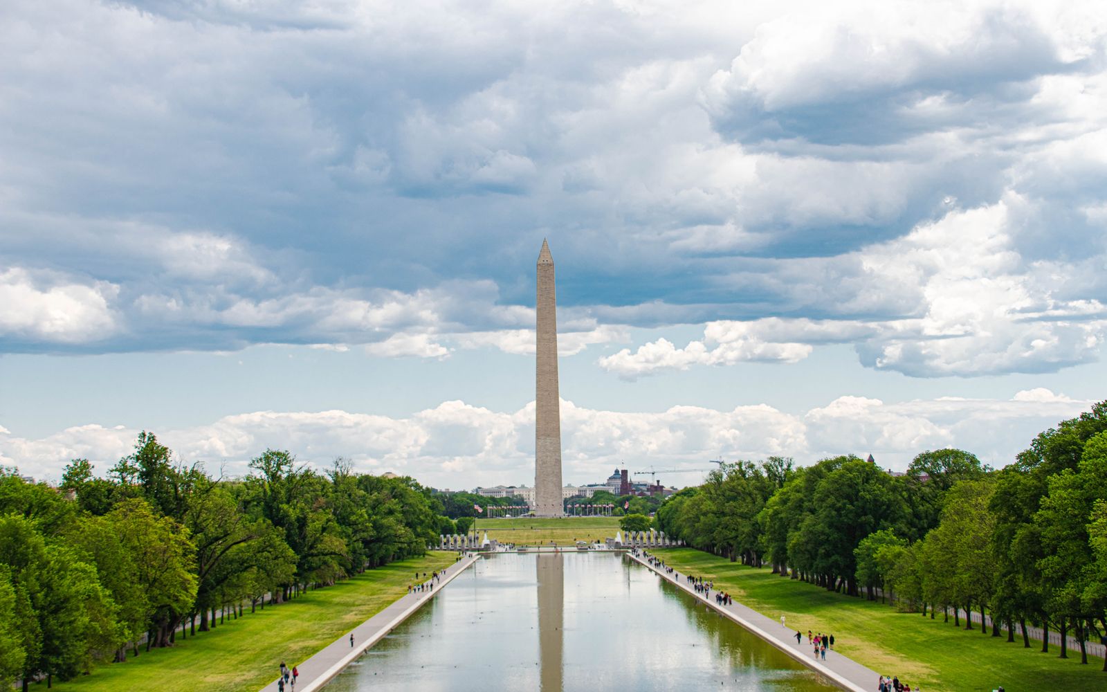 The Washington Monument and its reflection in the Reflecting Pool beneath an overcast sky in Washington, D.C.