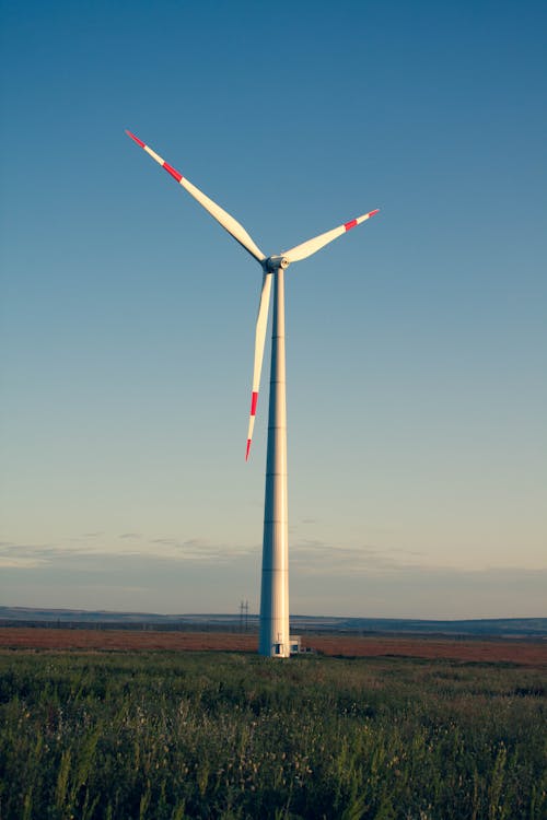 A White Windmill on a Grassy Field