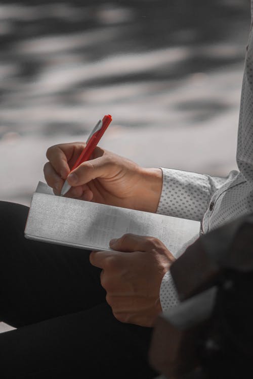 Foto profissional grátis de caderno, caneta, escrevendo