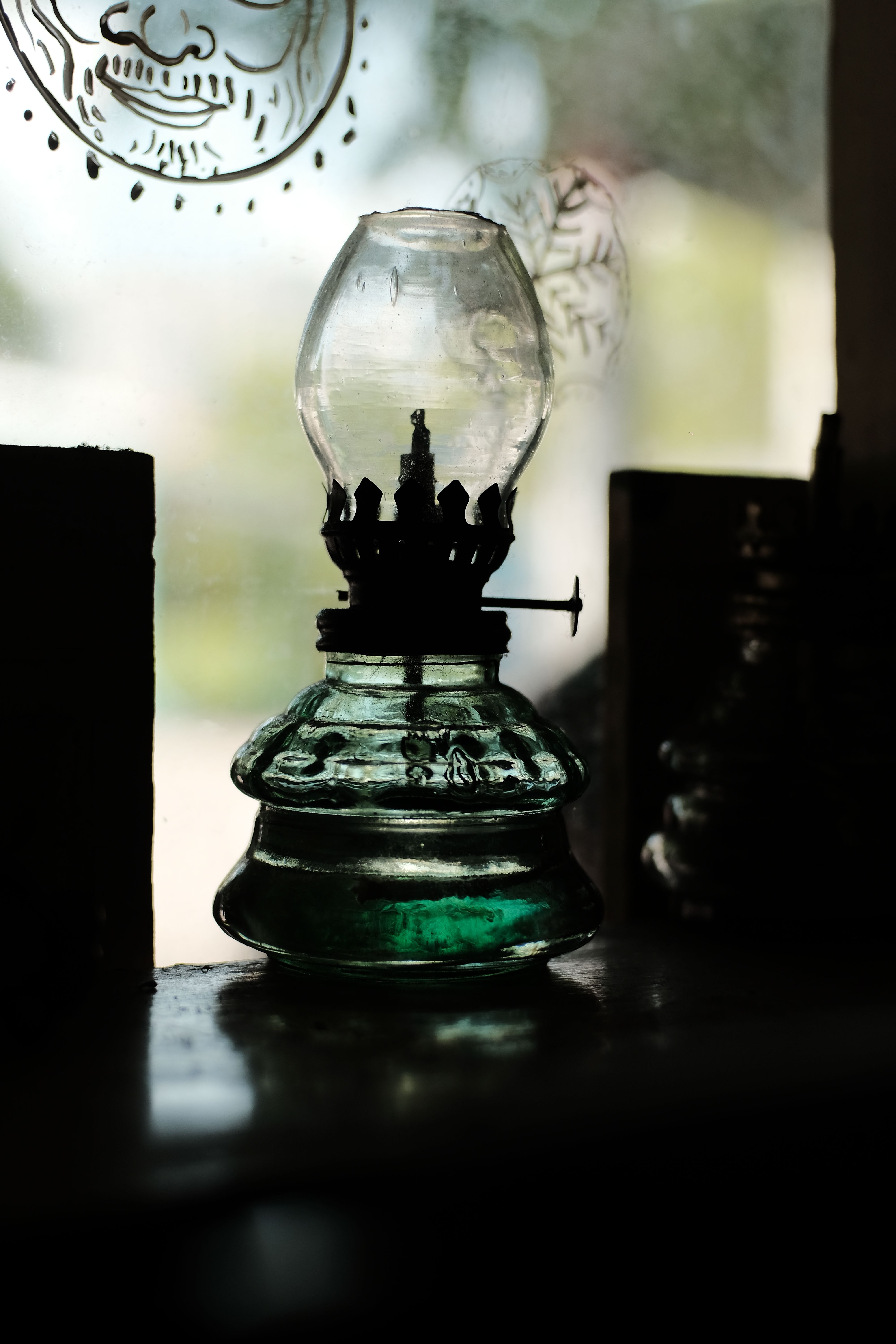 An oil lamp burning in a dark window - I, II and III John