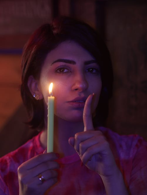 Close-Up Shot of a Woman Holding a Lighted Candle
