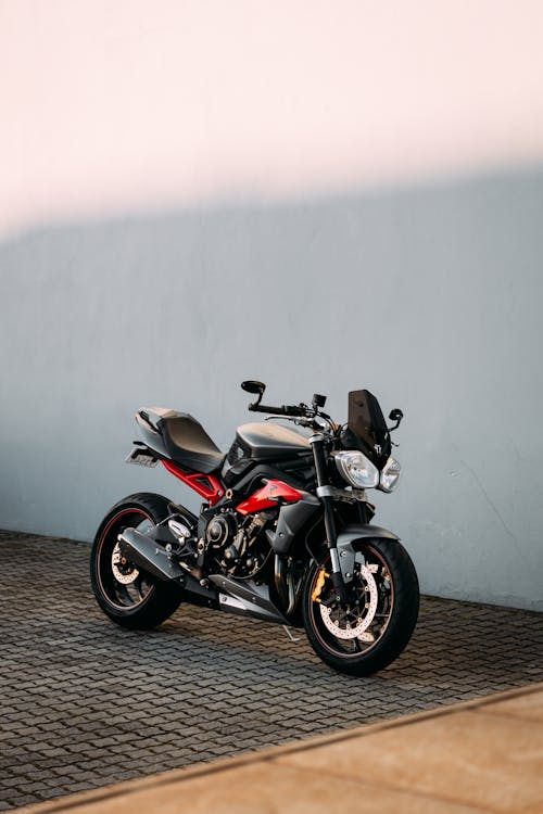 Free A Black and Red Motorcycle Parked on the Side  Stock Photo