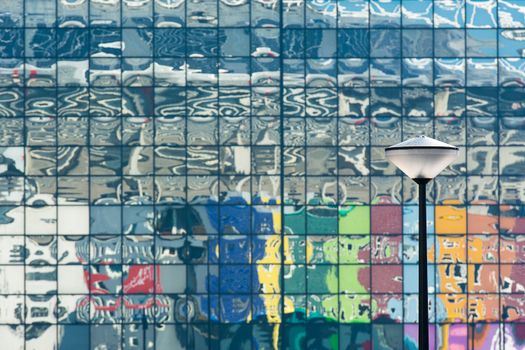 Artistic reflection of a colorful building facade with a street lamp in focus.