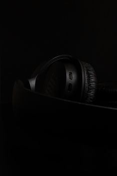 Close-up of black headphones against a dark background, emphasizing modern technology and minimalism.
