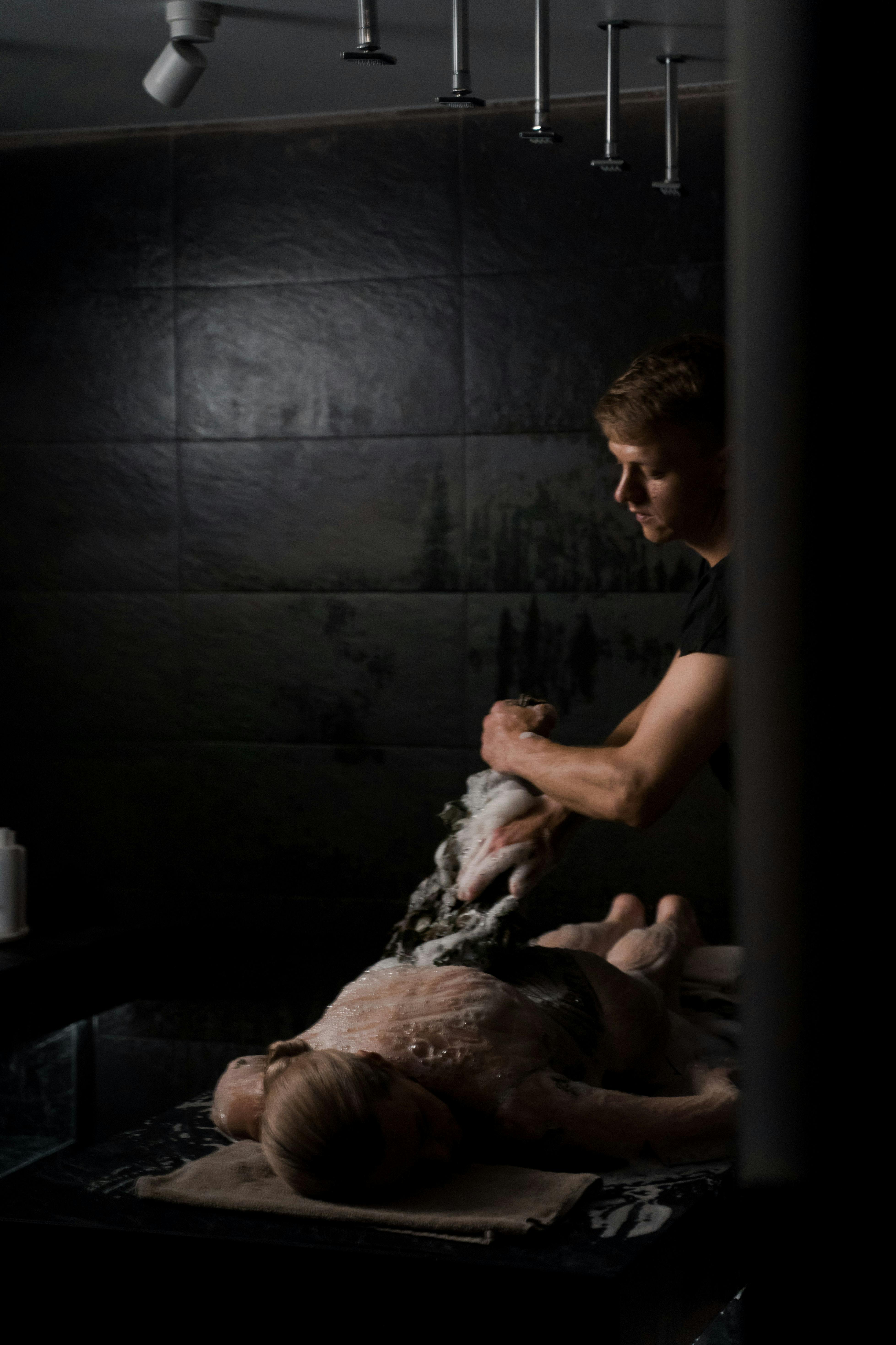Experience relaxation with a luxurious spa massage treatment, featuring a masseur applying suds to a client.