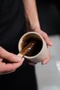 Person Holding Brown and White Paper Cup With Brown Powder