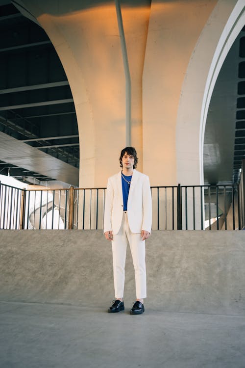 Free A Man in White Suit and Pants Standing on a Concrete Floor Stock Photo