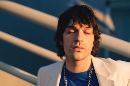 Free Portrait of a man with closed eyes basking in warm sunlight outdoors. Stock Photo