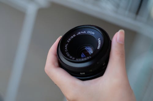 Person Holding Black Camera Lens