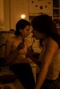Two Women Eating at the Kitchen at Night