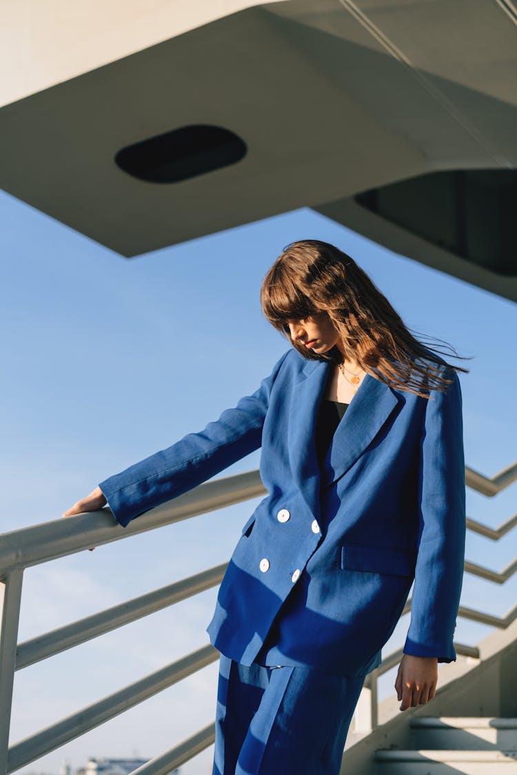 Woman In Blue Suit Holding Hand Rails 