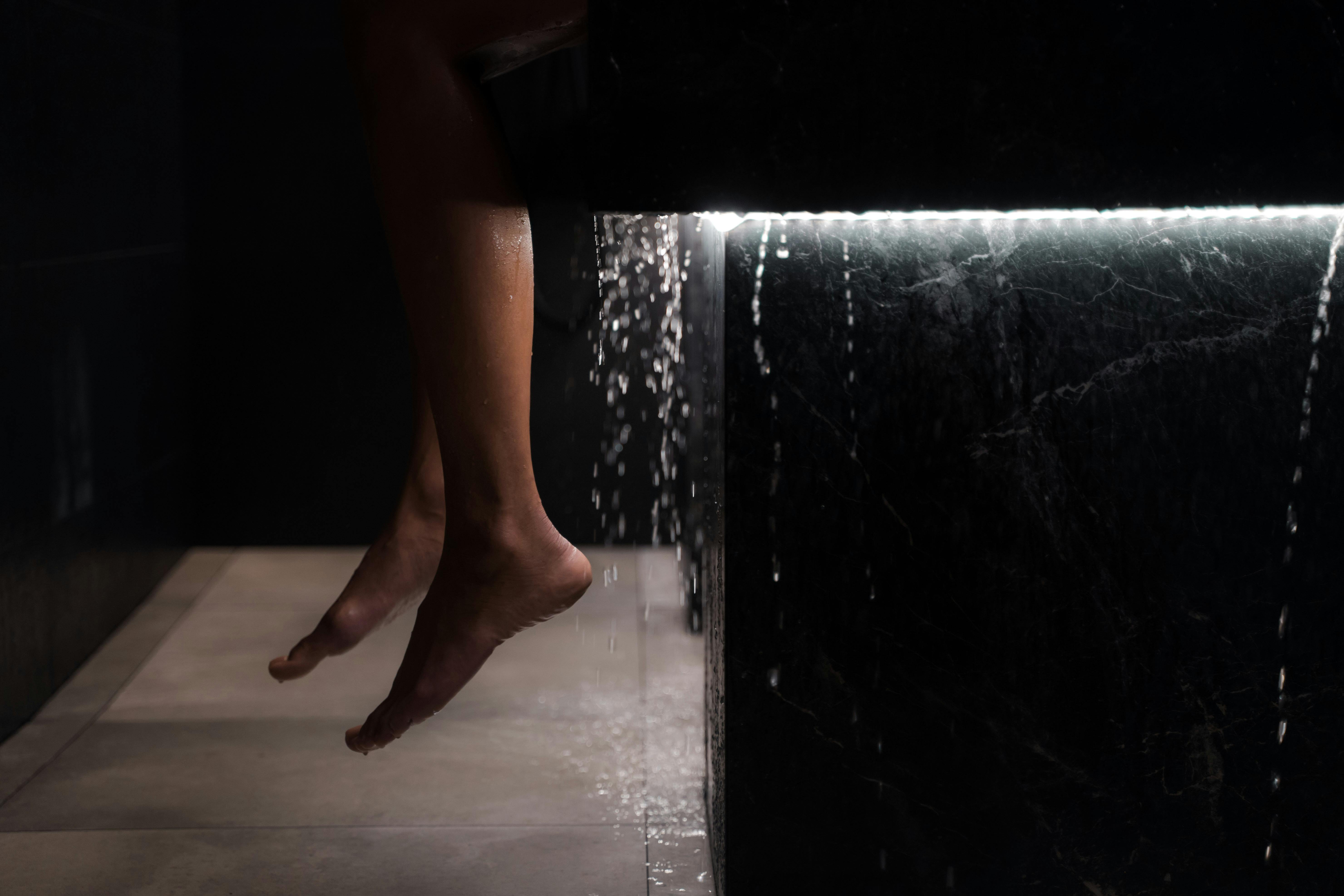 a person s feet near the dripping water