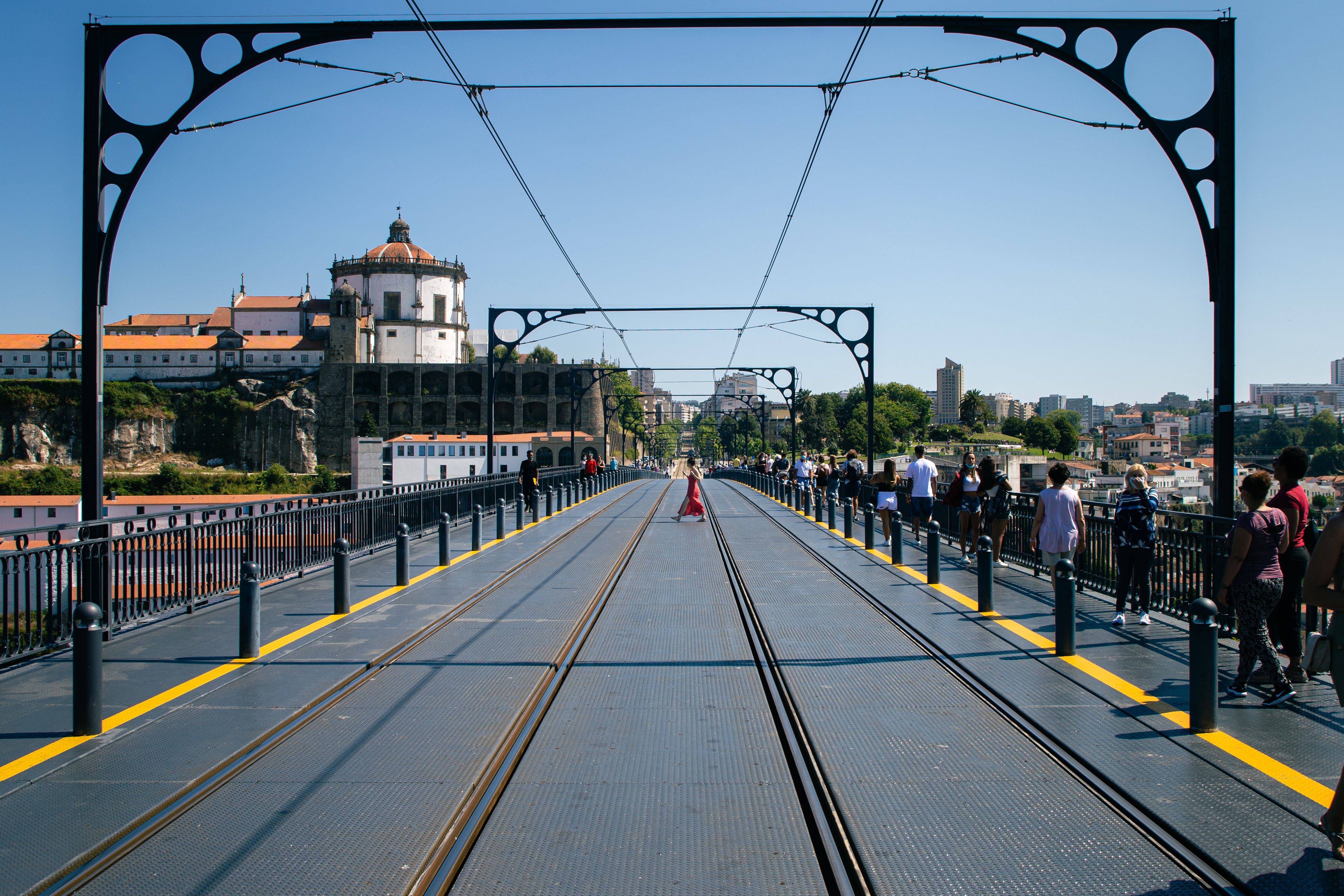 View of Luis I Bridge with Serra do Pilar Monastery and people walking in Porto, Portugal.