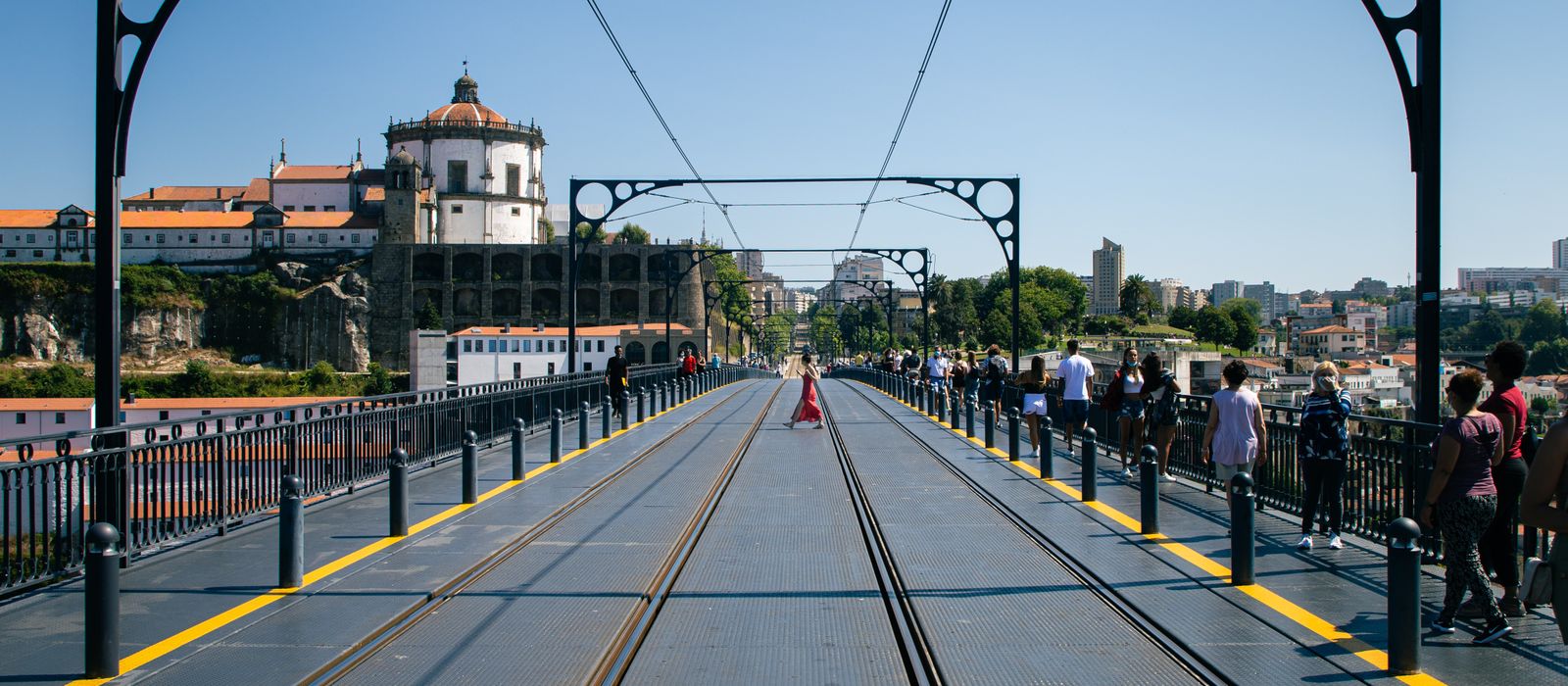 View of Luis I Bridge with Serra do Pilar Monastery and people walking in Porto, Portugal.