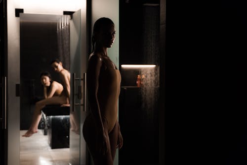 Elegant indoor spa setting with women in swimsuits, set against a moody, subdued ambiance.