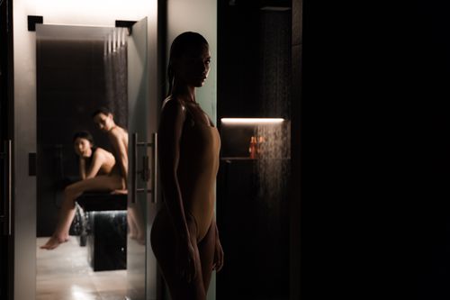 Free Elegant indoor spa setting with women in swimsuits, set against a moody, subdued ambiance. Stock Photo