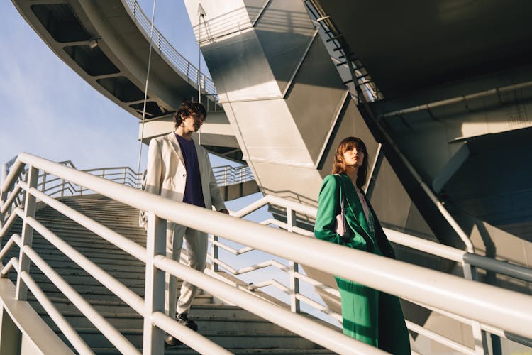 A Man And Woman Walking Down The Stairs