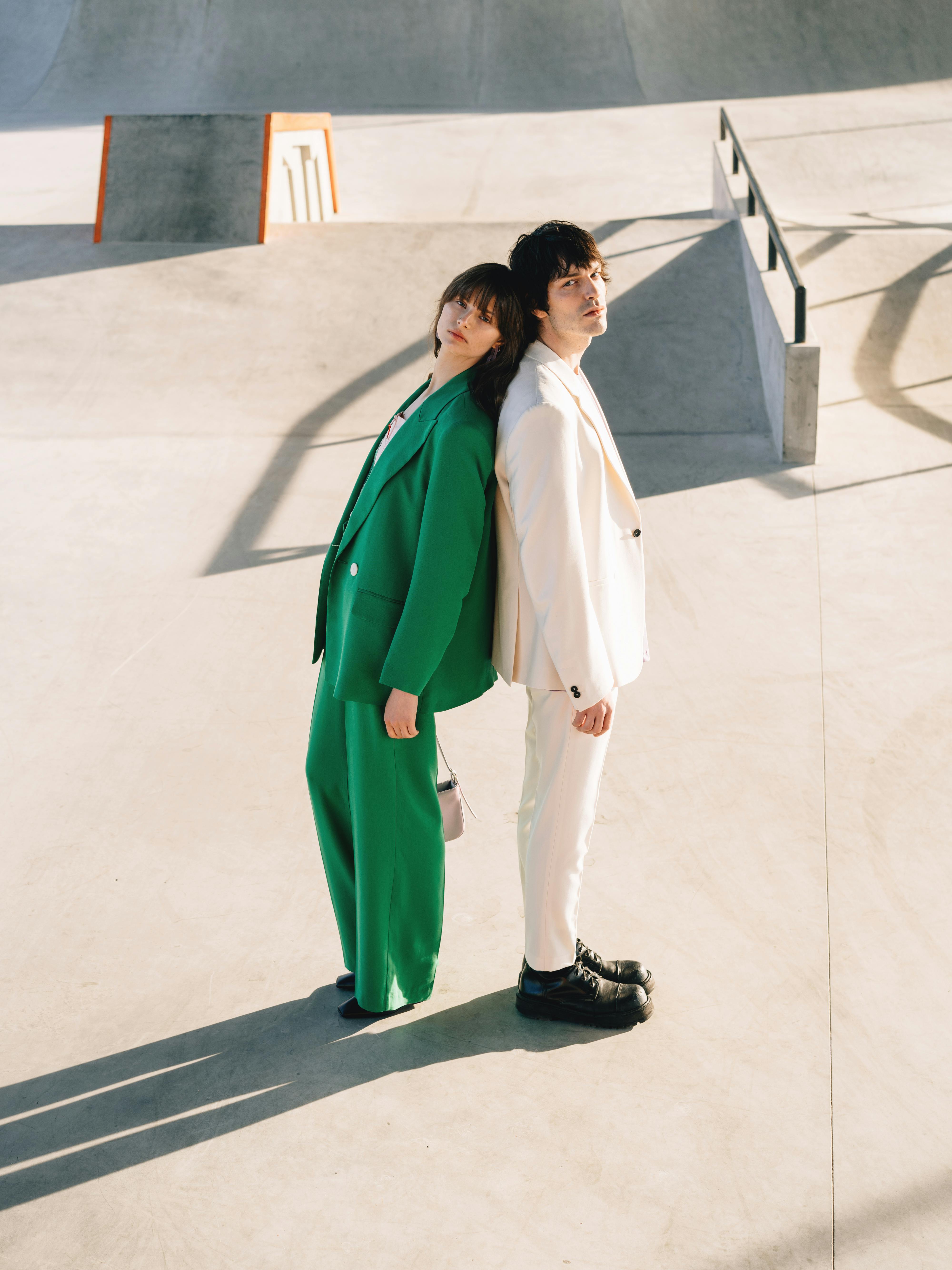 a couple in formal wear standing back to back