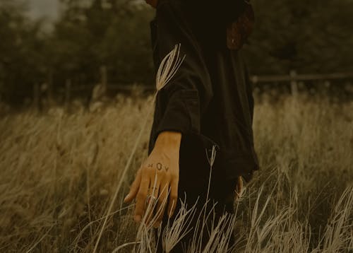 Close-Up Shot of a Person Standing on a Grass Field