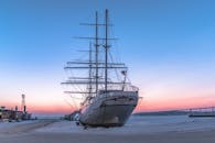 在德国施特拉尔松德港停靠的一艘历史悠久的船只，映衬着迷人的日落景色