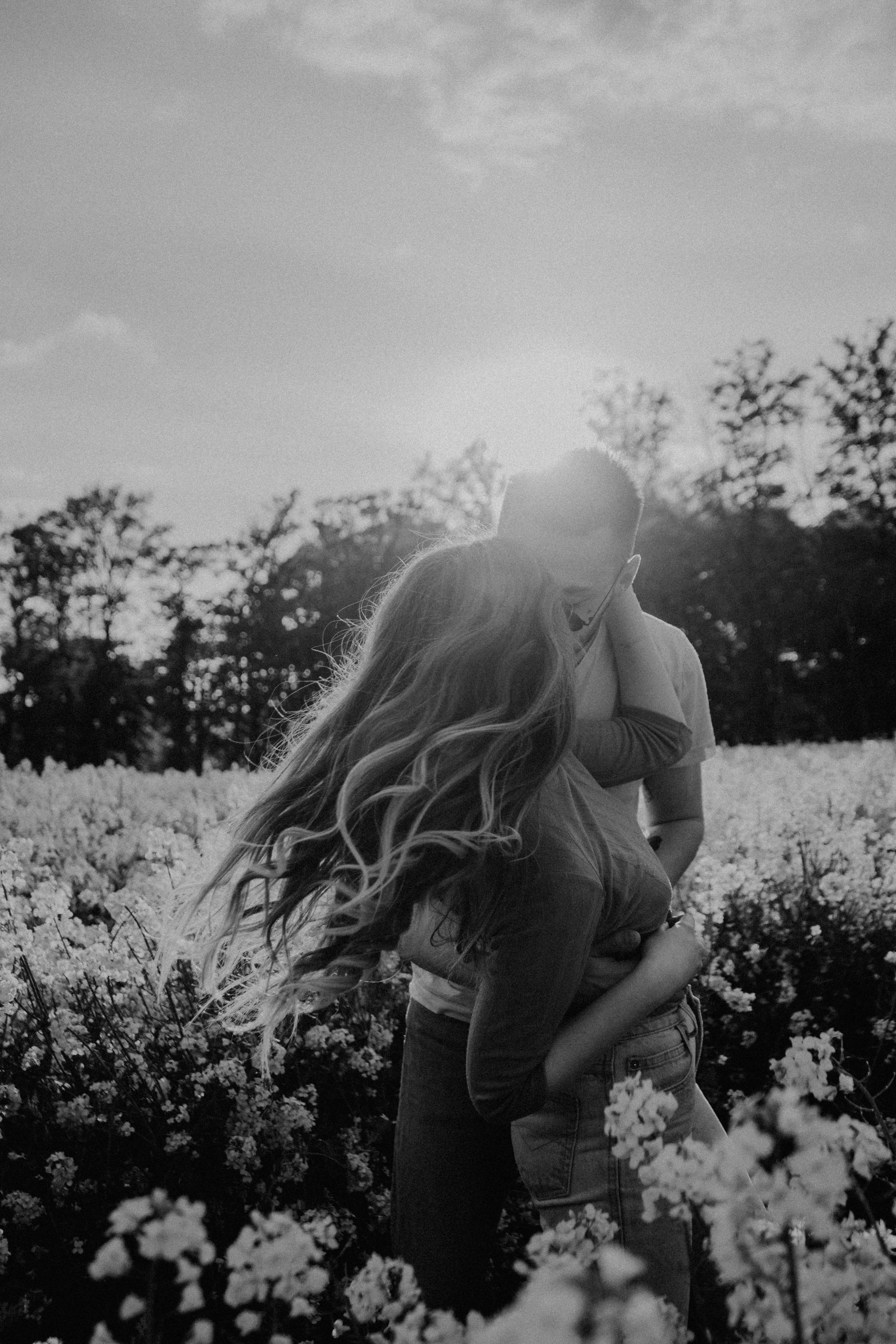 Free Grayscale Photo of Couple Kissing on Flower Field Stock Photo