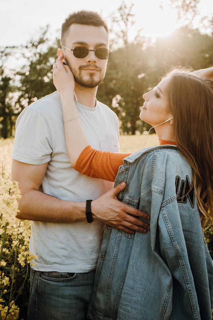 Young Couple Standing Together On A Field In Summer 