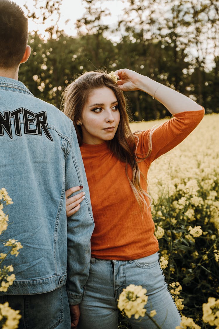 Couple Standing On A Field With Flowers 