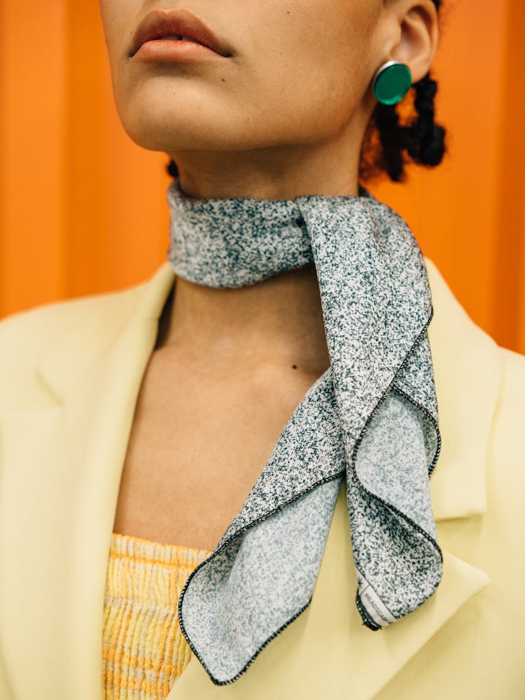 A Woman In Yellow Blazer Wearing A Gray Scarf