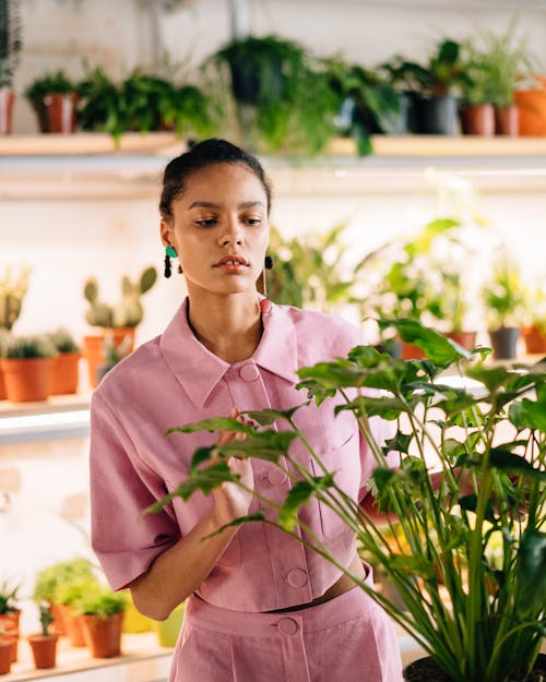 A Woman in Pink Shirt Looking at the Green Plants