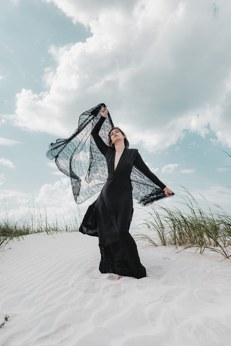 Woman In Black Clothes Walking On The Beach