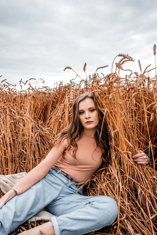 Woman in Denim Pants Posing on Wheat Field