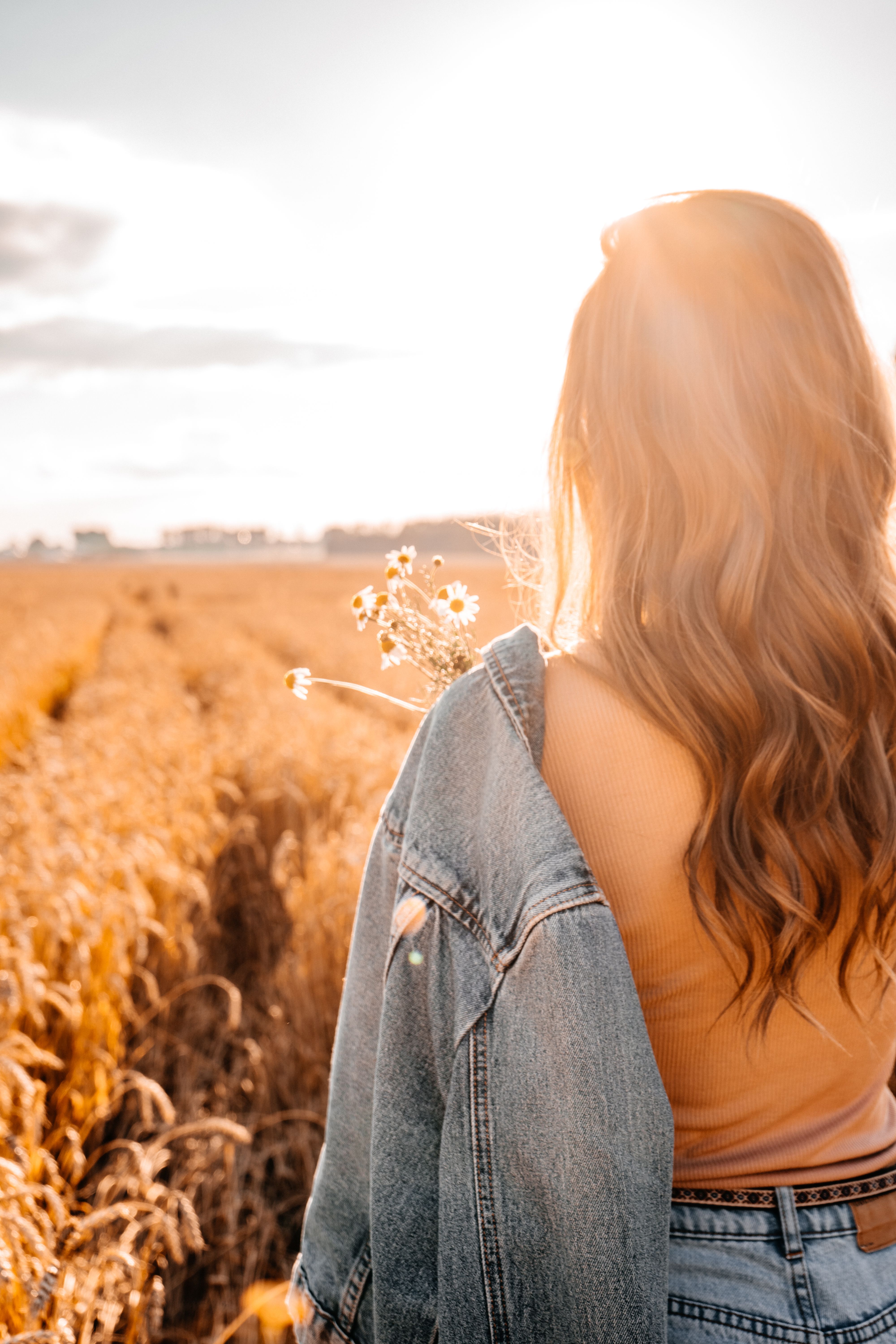 Back View of a Woman Walking on a Wheat Field in Summer · Free Stock Photo