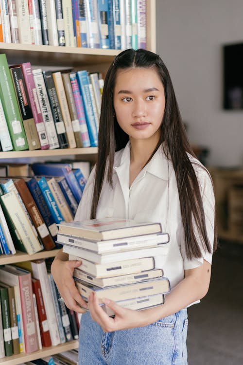 Free Woman in White Button Up Shirt Holding Books Stock Photo