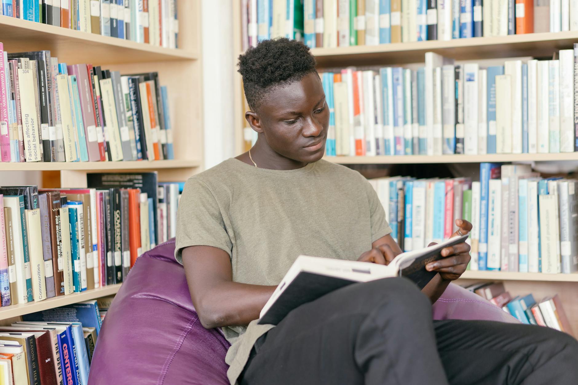 https://www.pexels.com/photo/man-in-brown-crew-neck-t-shirt-reading-book-9158365/