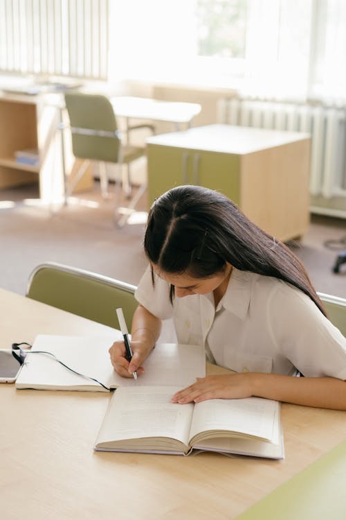 Free A Woman Studying Inside the Library Stock Photo