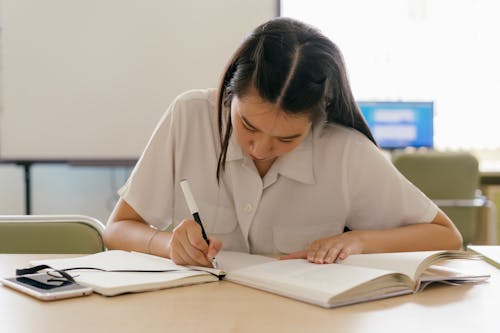 Free A Woman Studying Inside the Library Stock Photo