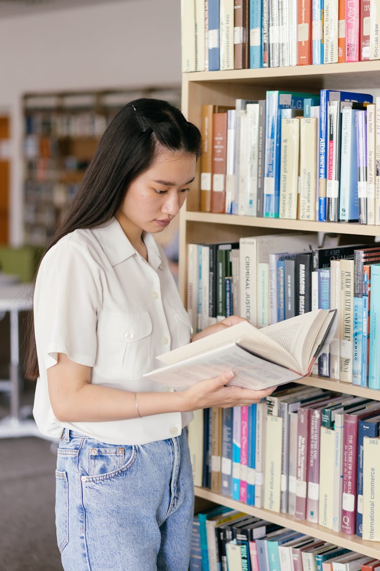 A Female Student Reading A Book