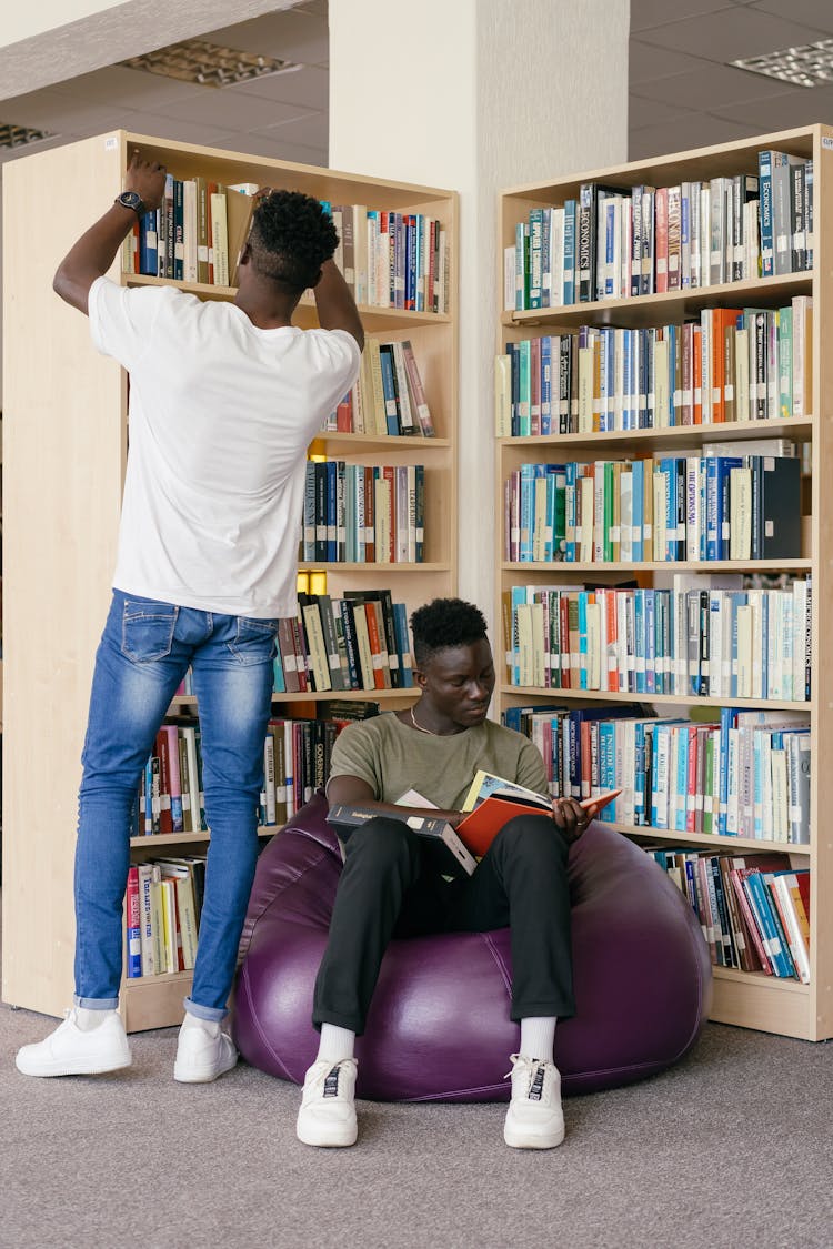 Men In The Library Holding Books